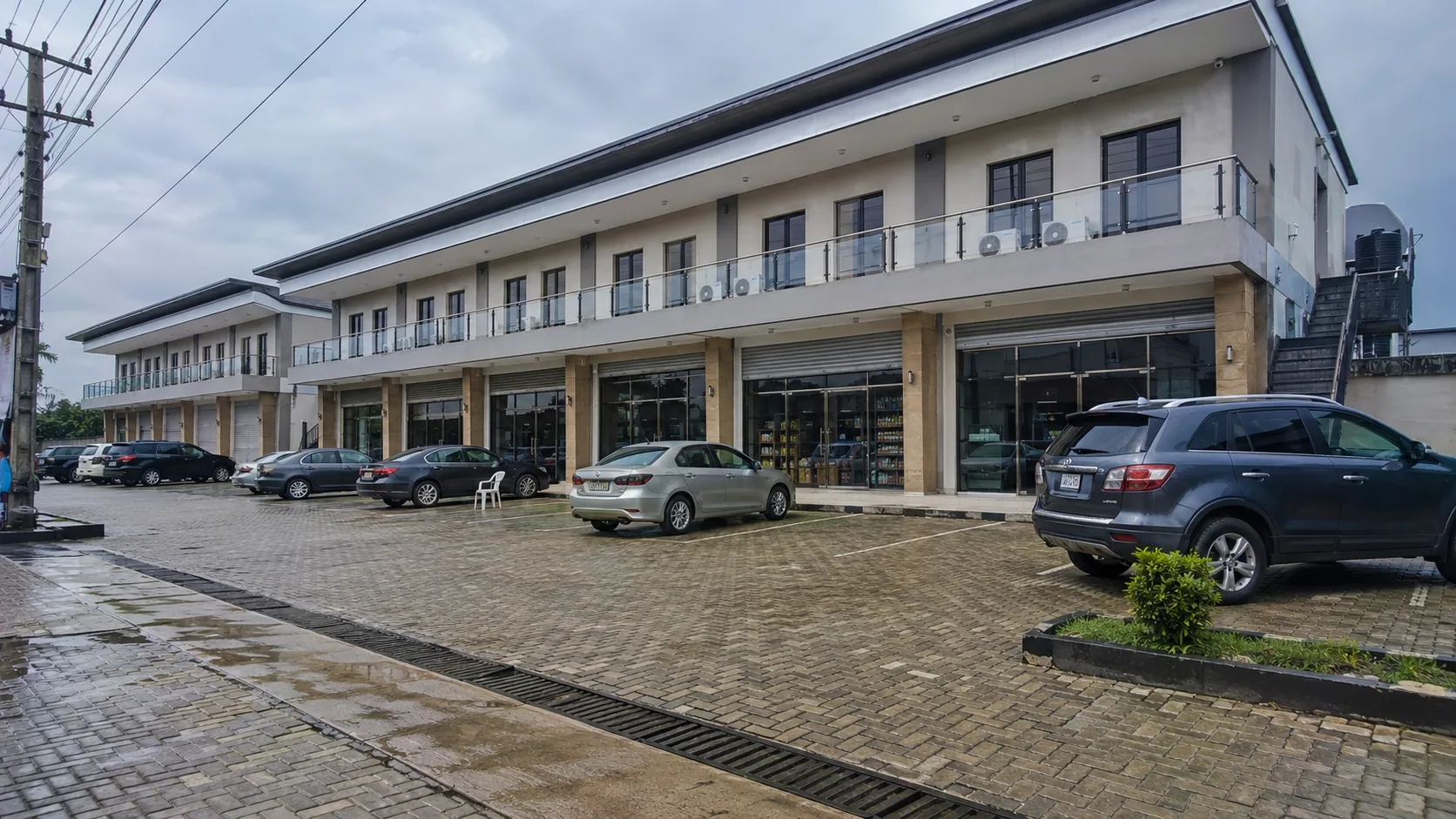 Completed two-storey commercial plaza with paved parking and glazed shopfronts