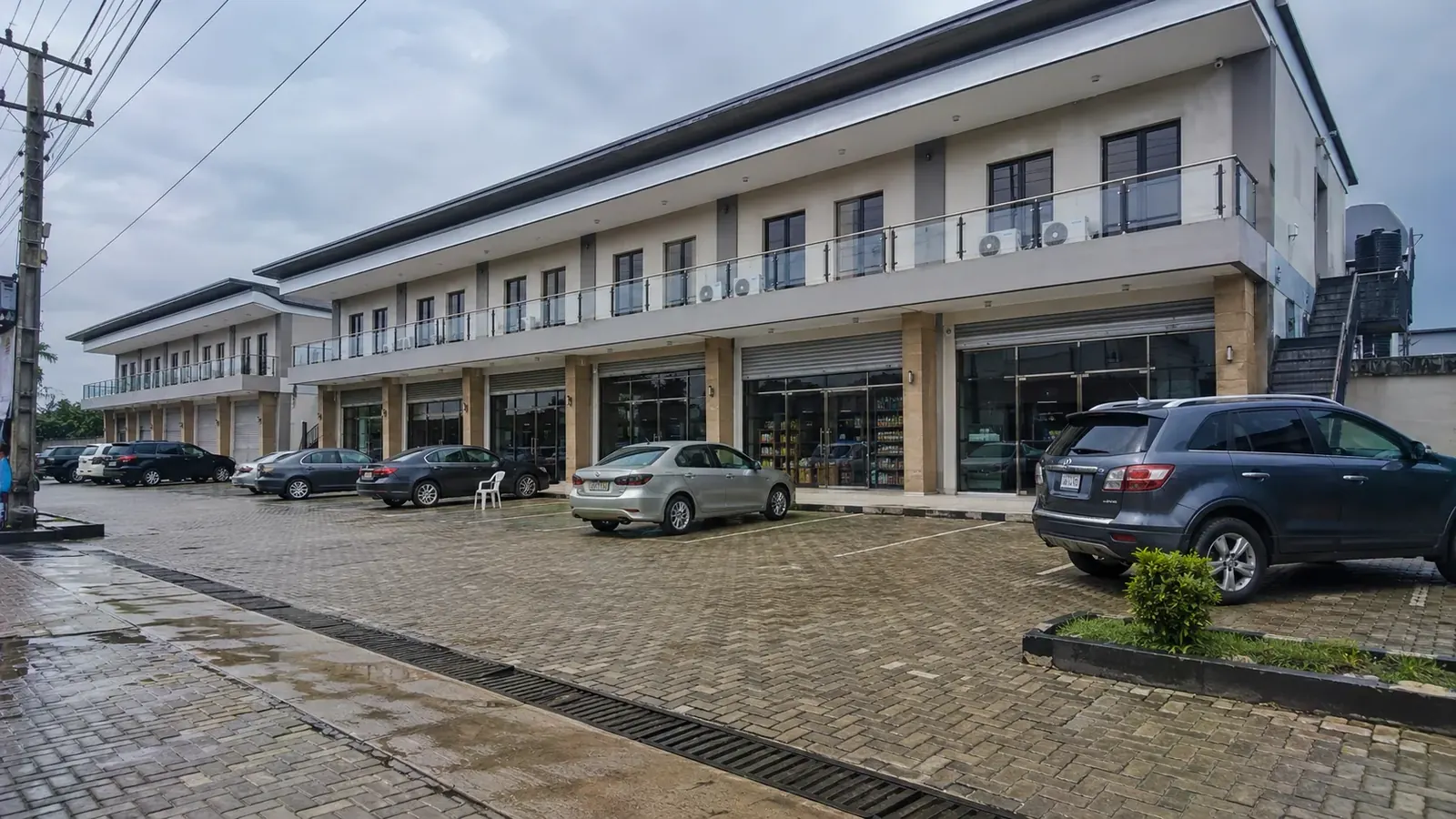 Completed two-storey commercial plaza with paved parking and glazed shopfronts