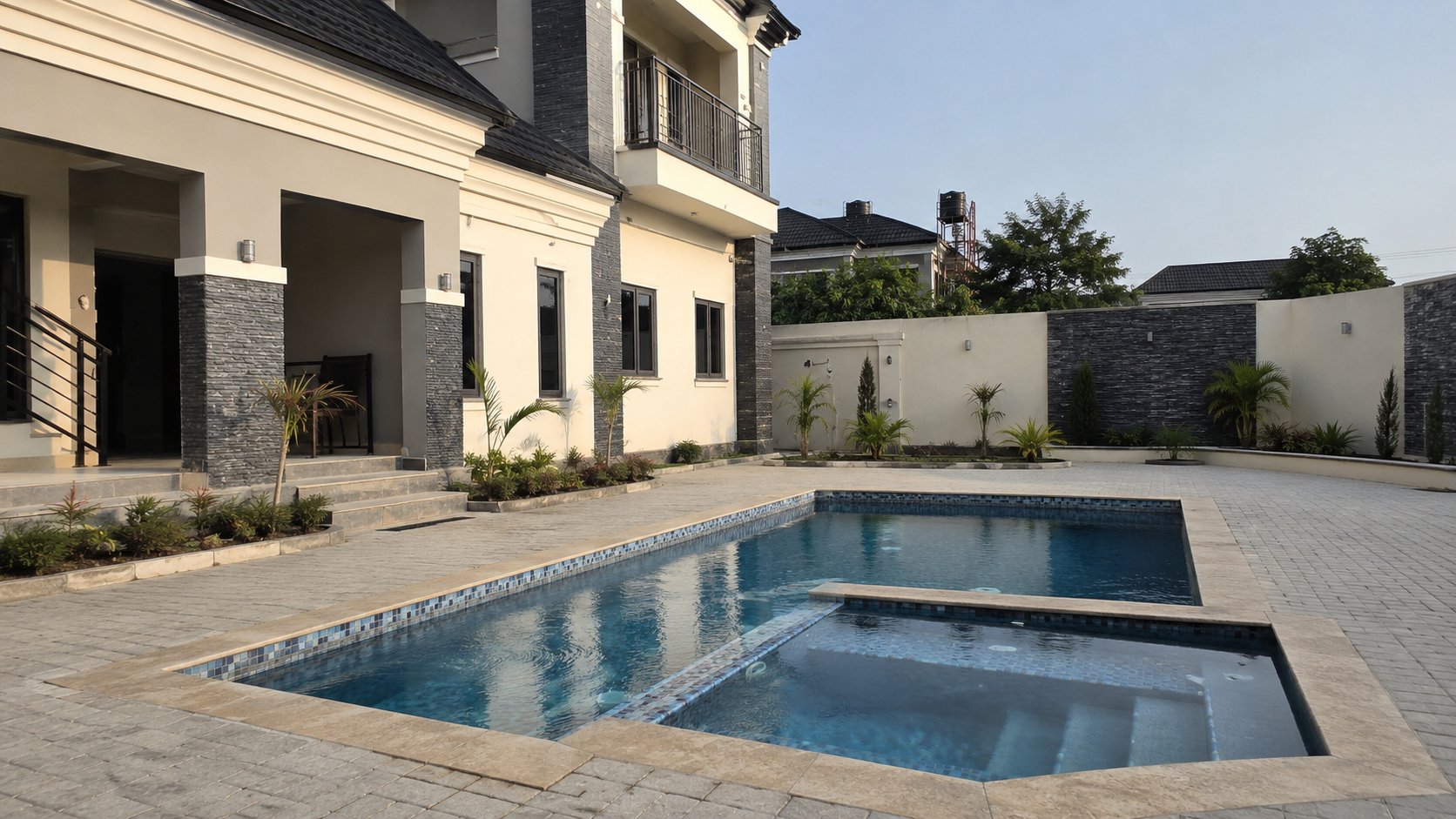 Completed swimming pool and spa integrated into a paved residential courtyard